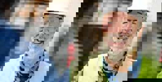 British Safety Council Audit Services - Middle aged man with beard with hard hat and hi visibility vest smiling.