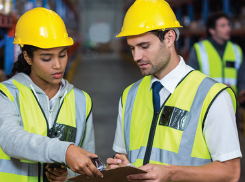 Two people in high vis jackets and hard hats conducting a risk assessment