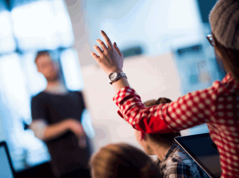 Woman with hand raised asking a question