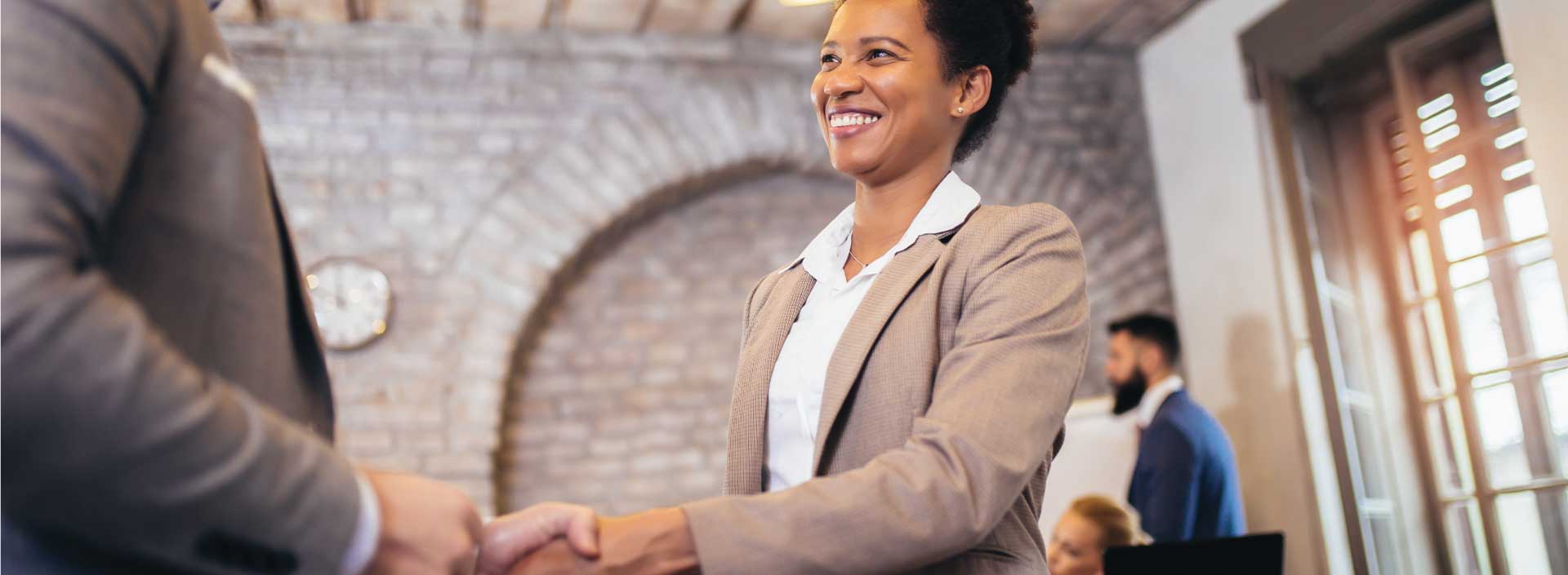 Woman smiling shaking someones hand
