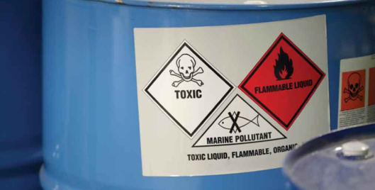Blue vat of chemicals labelled toxic, flammable liquid and marine pollutant