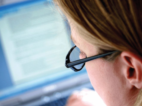 Woman wearing glasses working on a computer